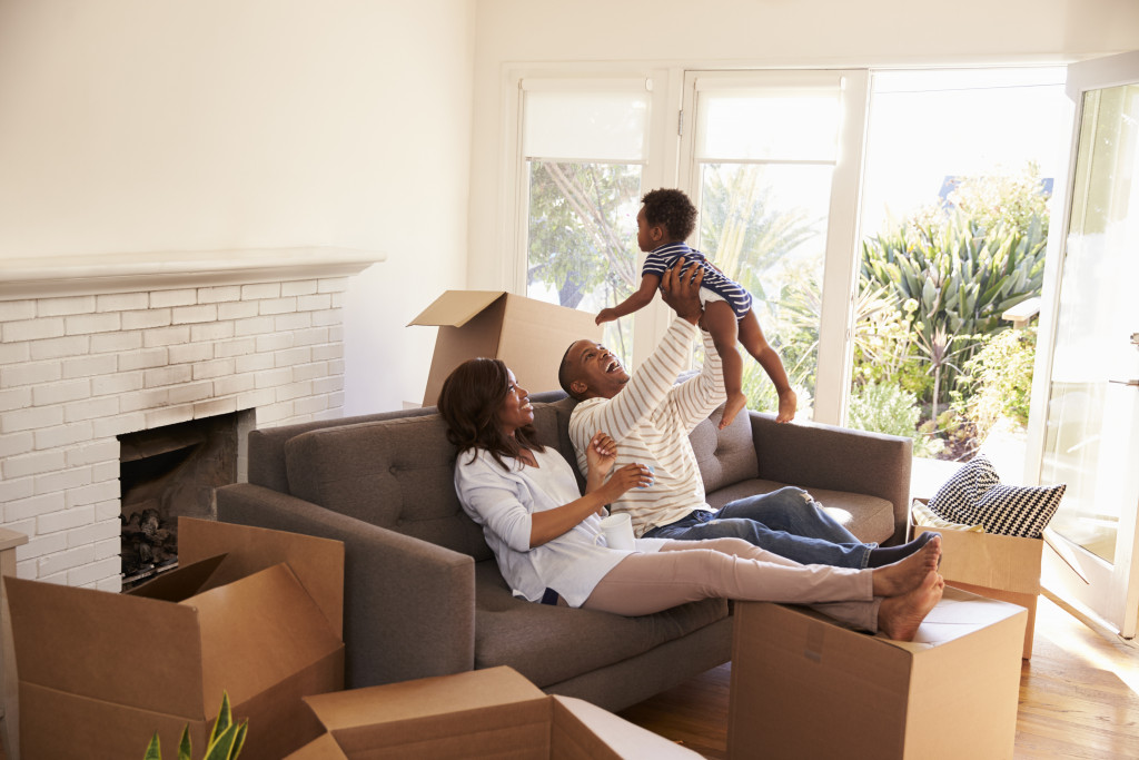 a young family resting and playing while moving into a new home